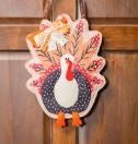A whimsical turkey decoration hangs on a front door